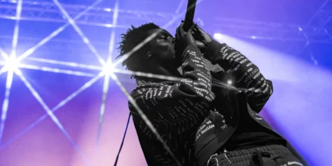 Chanteur sur scène sous des lumières bleues éclatantes.
