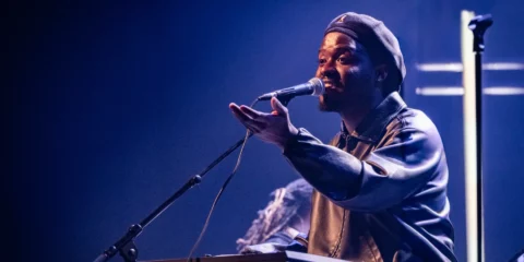 Chanteur au clavier Yamaha lors d'un concert en lumière bleue.